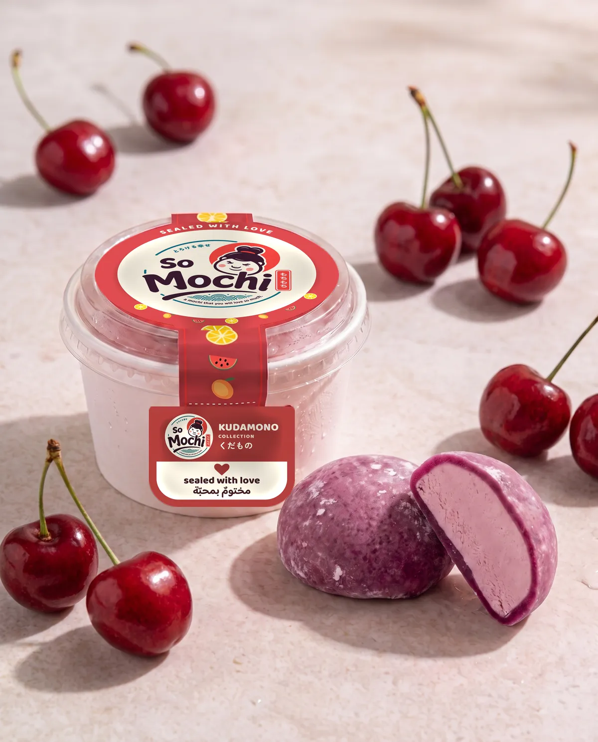 Jumbo Cherry Mania mochi, whole and cut open, beside its sealed So Mochi cup