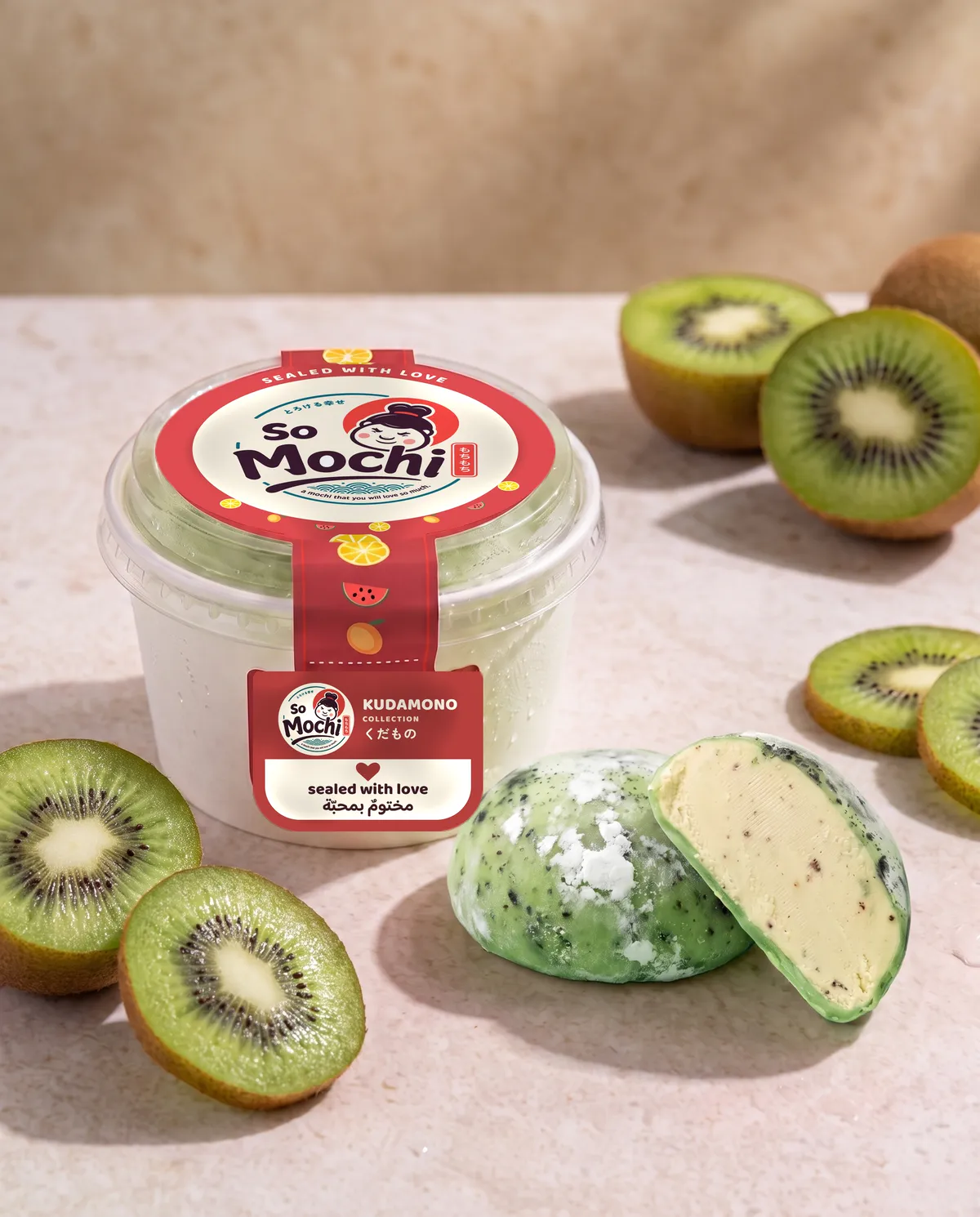 Jumbo Kiwi mochi, whole and cut open, beside its sealed So Mochi cup