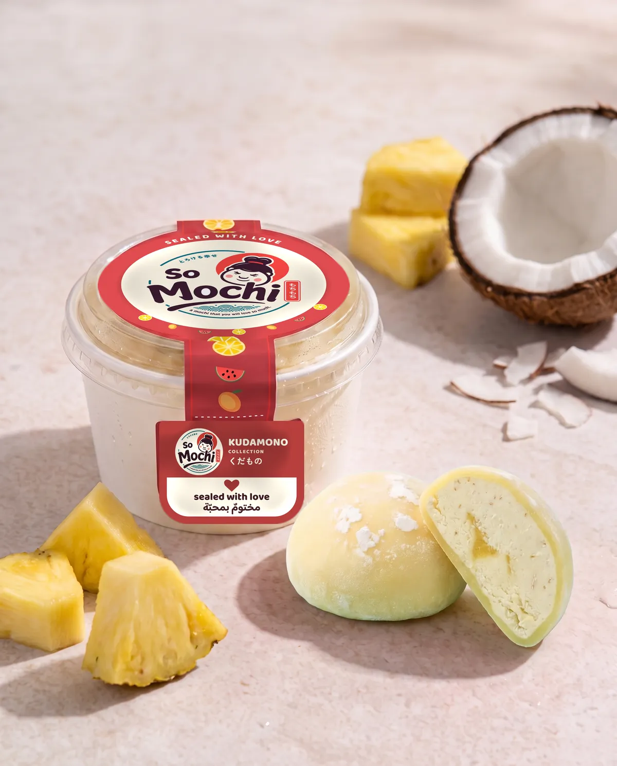 Jumbo Piña Colada mochi, whole and cut open, beside its sealed So Mochi cup