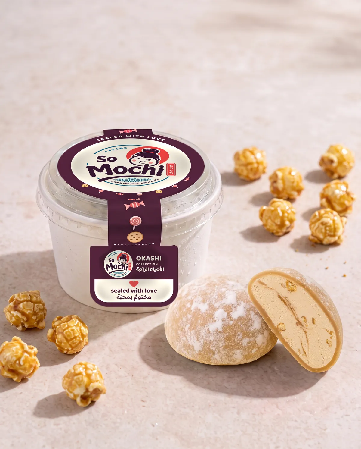 Jumbo Popcorn Caramel mochi, whole and cut open, beside its sealed So Mochi cup