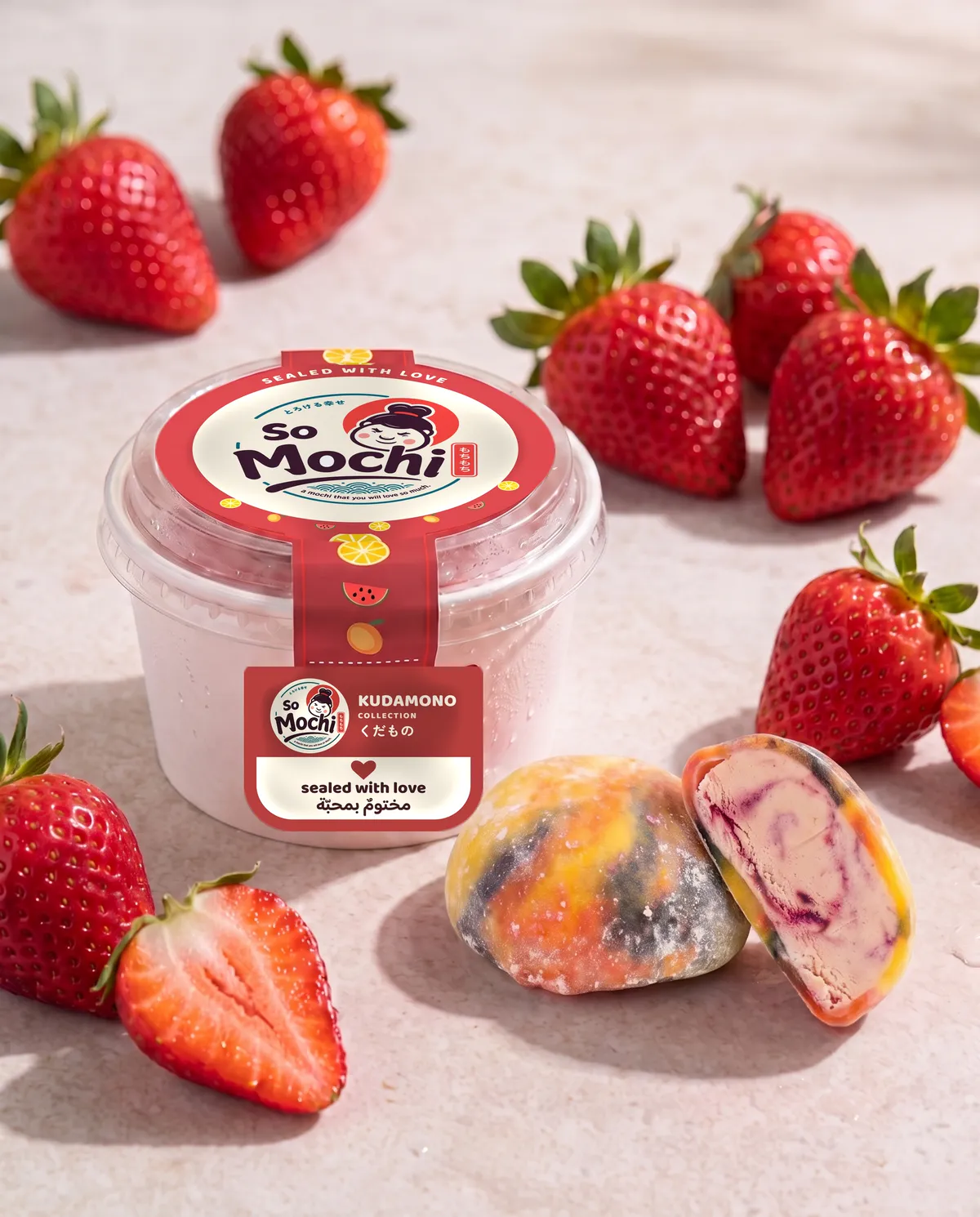 Jumbo Rainbow mochi, whole and cut open, beside its sealed So Mochi cup