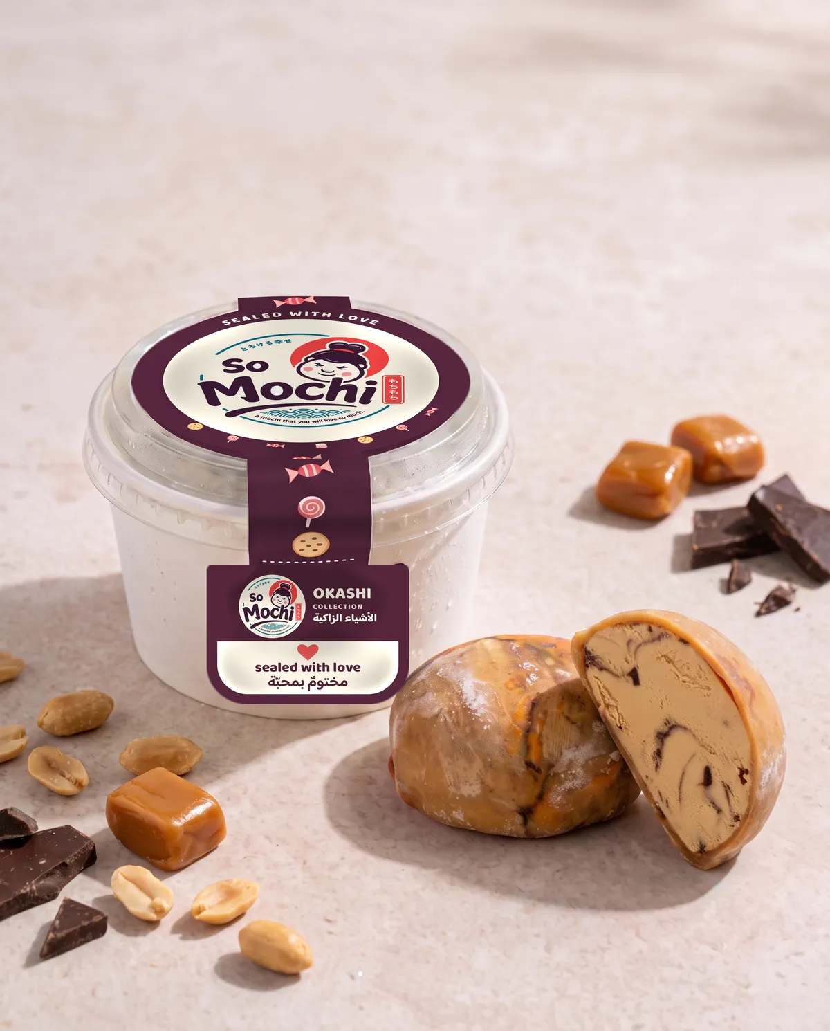 Jumbo Snickers mochi, whole and cut open, beside its sealed So Mochi cup