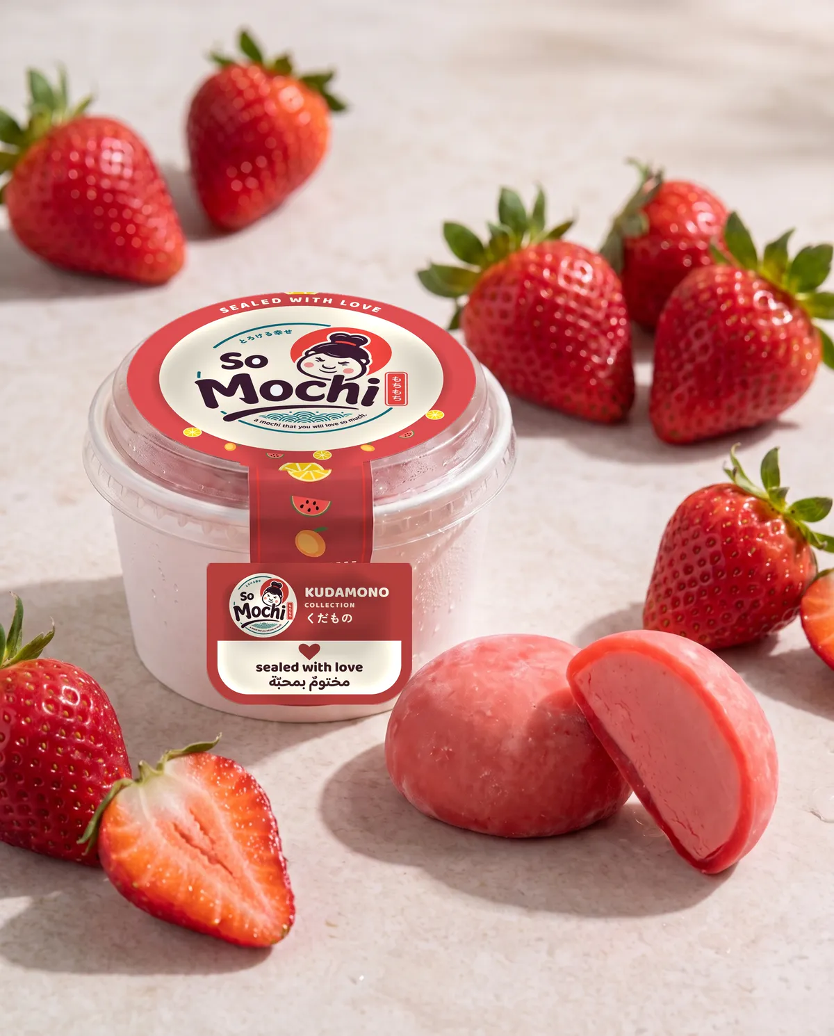 Jumbo Strawberry mochi, whole and cut open, beside its sealed So Mochi cup