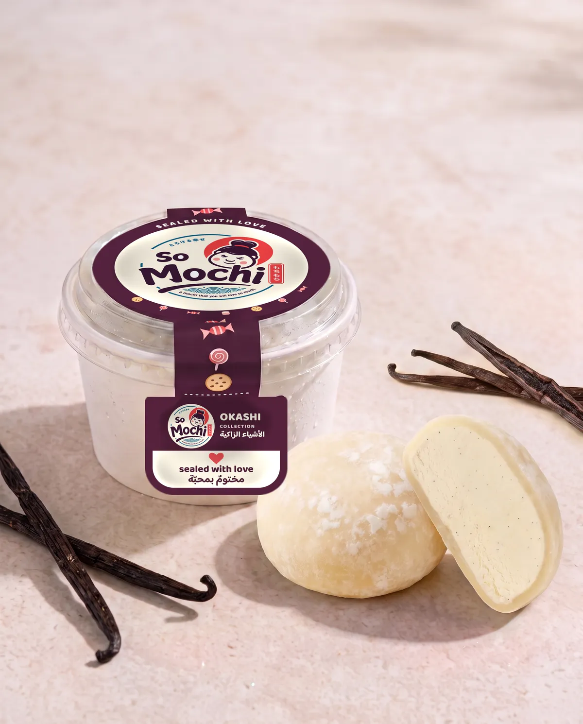 Jumbo Vanilla mochi, whole and cut open, beside its sealed So Mochi cup